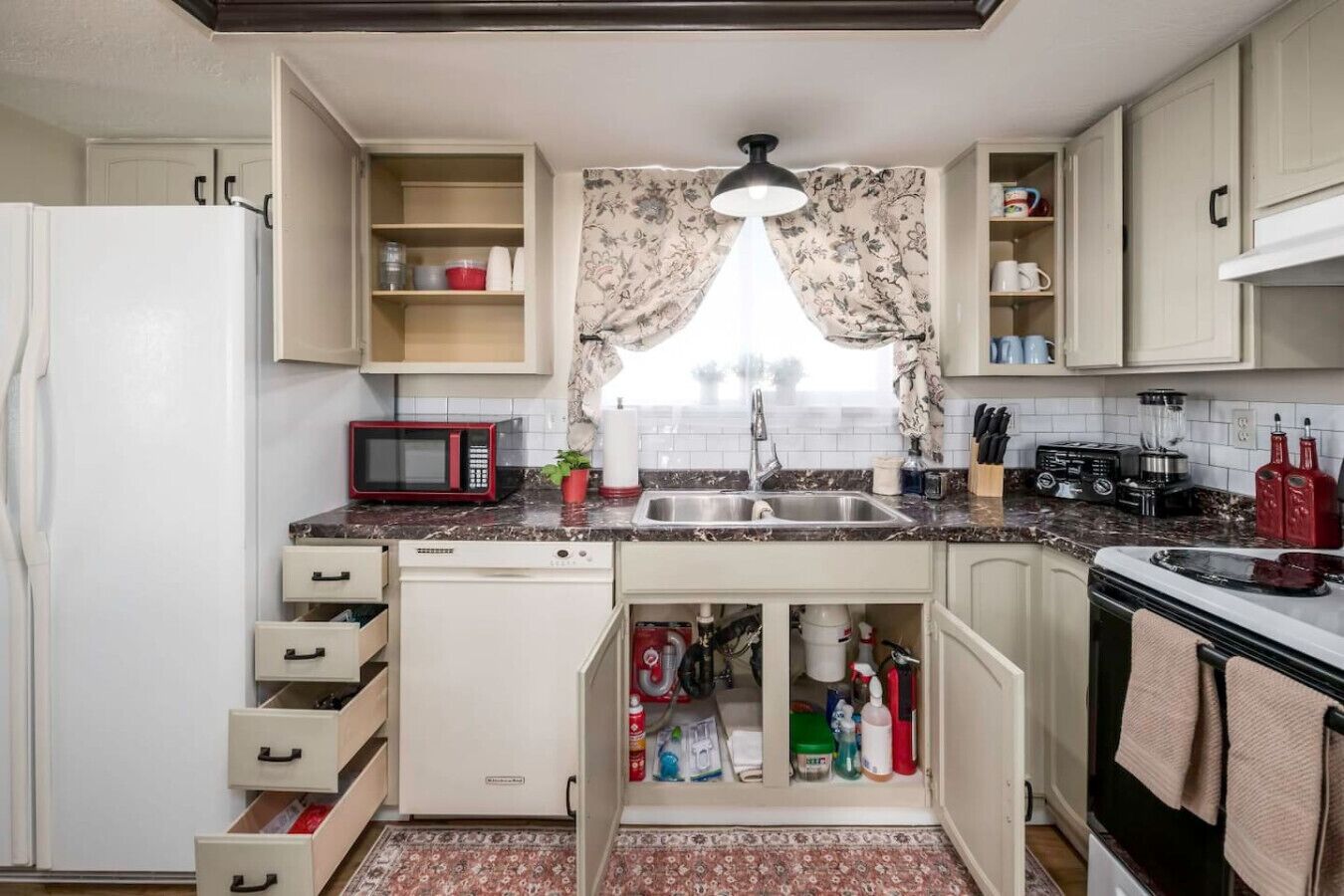 Une cuisine compacte équipée d’un four à micro-ondes, d’un évier et de divers appareils électroménagers.