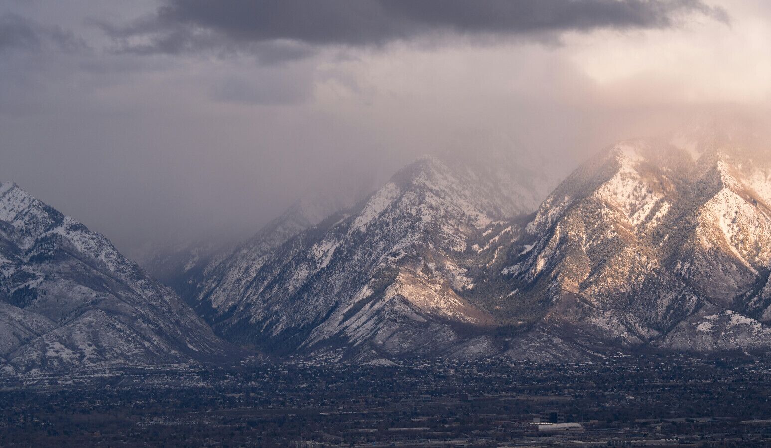 A mountainous landscape with snow-covered peaks and a valley below.