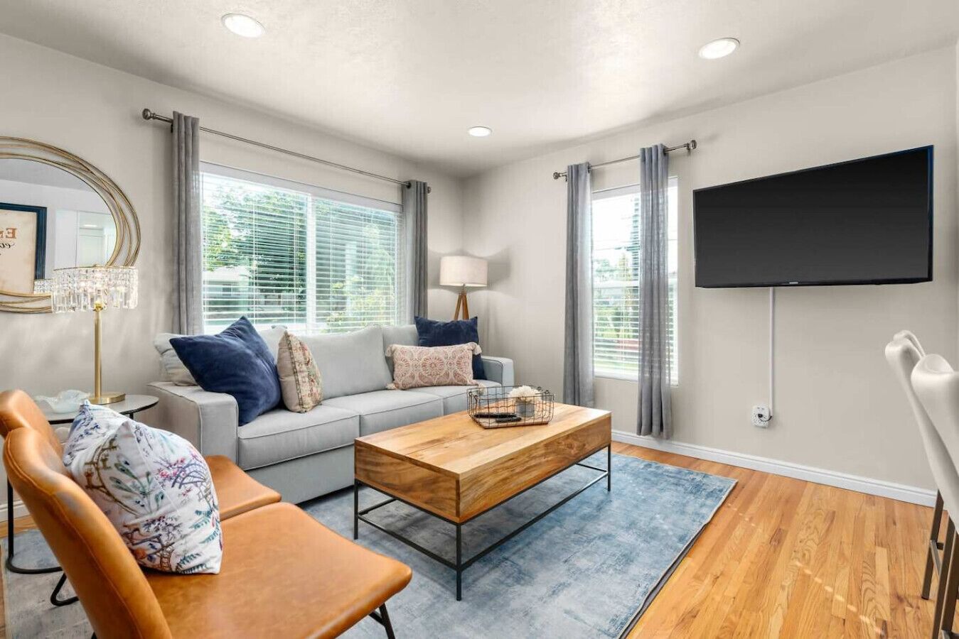 A modern living room with a sofa, coffee table, and a TV mounted on the wall.