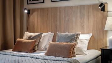 A neatly made bed with a textured duvet, a wooden headboard, and multiple pillows.
