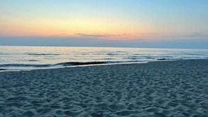 A beach with waves and a clear sky.