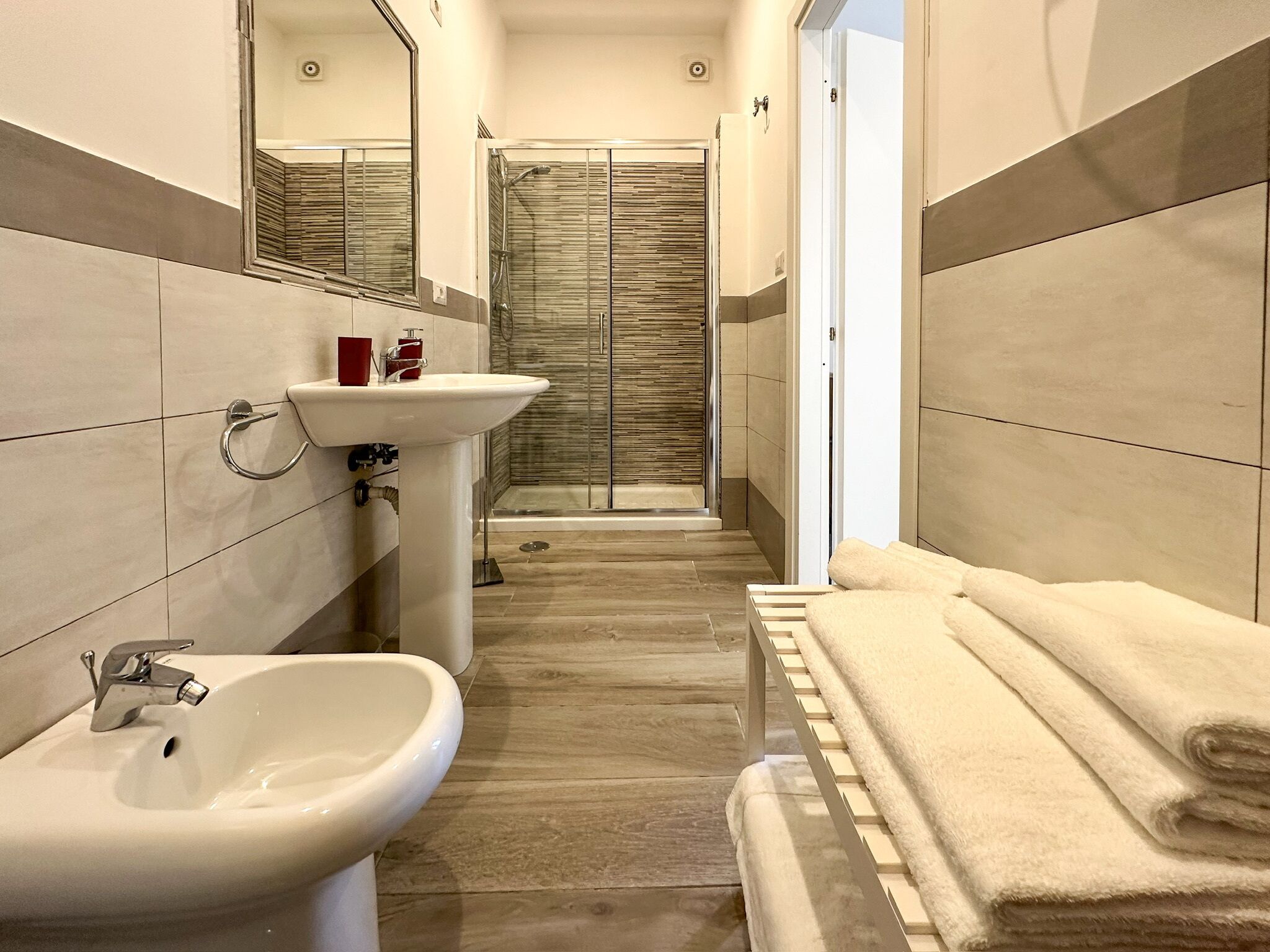 Un bagno moderno con lavandino, specchio e doccia.