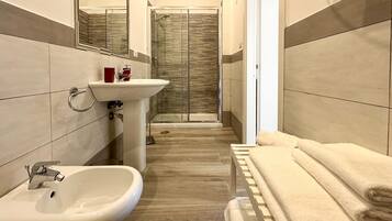 Un bagno moderno con lavandino, specchio e doccia.