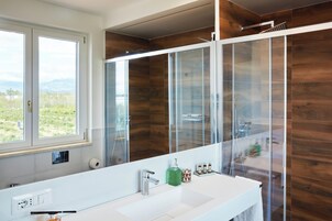 Habitación triple, vistas al jardín | Baño | Artículos de higiene personal gratuitos, secador de pelo y albornoces