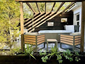 A wooden pergola with a hot tub and seating area, surrounded by greenery. - House with Hot Tub, 10 mins to the Beach (Miami)
