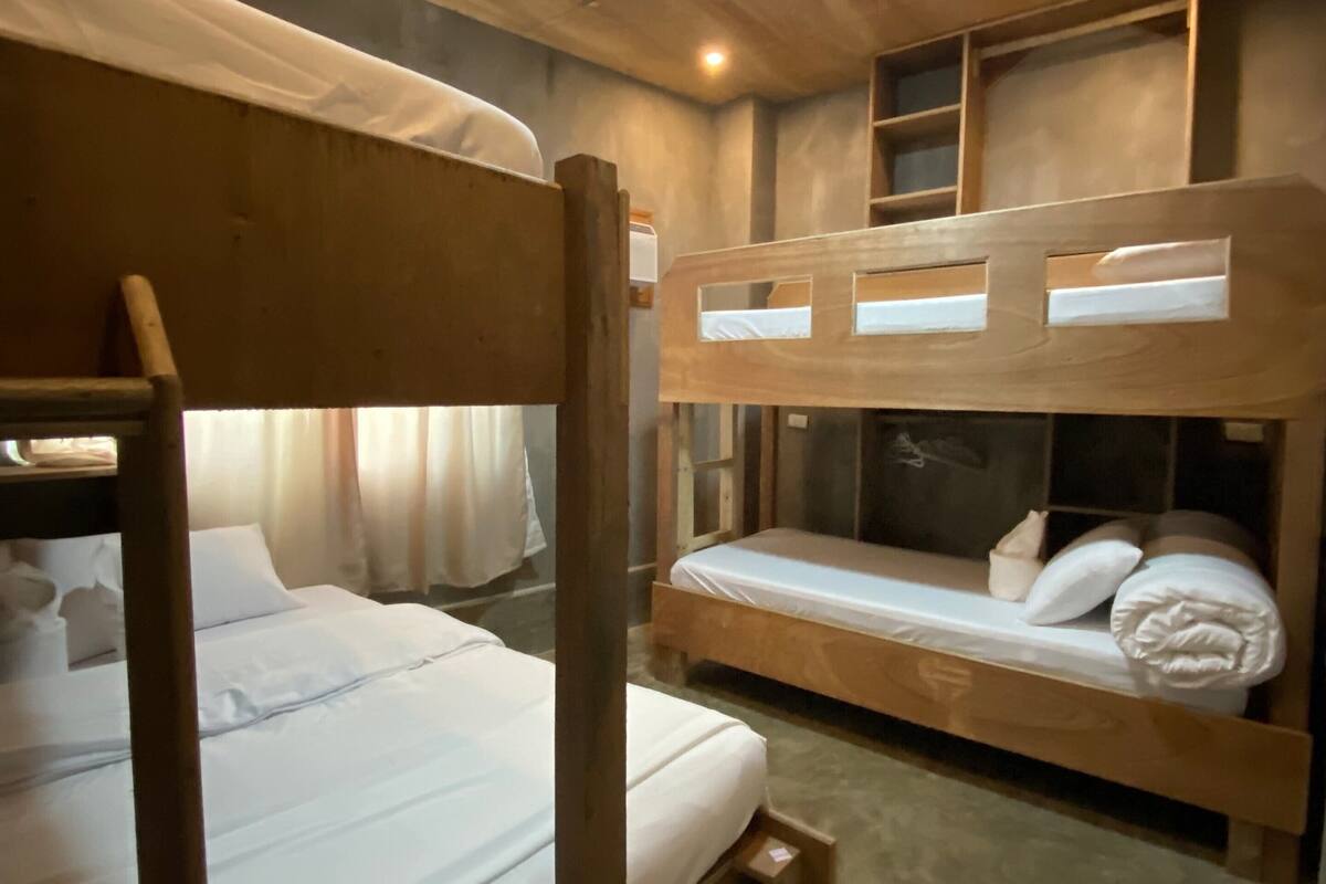 A bunk bed room with wooden walls and a ceiling light.