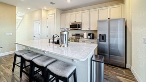 A kitchen with a large island, stainless steel appliances, and a trash can. - Kid-Friendly, themed vacation home close to Disney/Universal (Kissimmee)