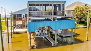 A waterfront house with a covered dock and a second-story balcony.