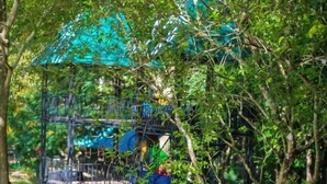 Un parque infantil con un tobogán azul y estructuras para escalar.