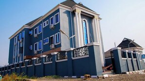 A multi-story residential building with a blue exterior, multiple windows, and a gated entrance. - Dopad Hills Hotel and Suites (Ibadan)
