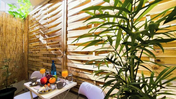 Uma área de refeições com uma mesa posta para dois, incluindo uma refeição e bebidas.