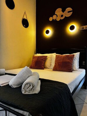 Una habitación de hotel con cama, almohadas y toallas.