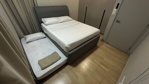 A compact room with a bed, a small table, and a wardrobe. - 1-bedroom apartment in marvelous Kuala Lumpur with free WiFi + Netflix (Wilayah Persekutuan)