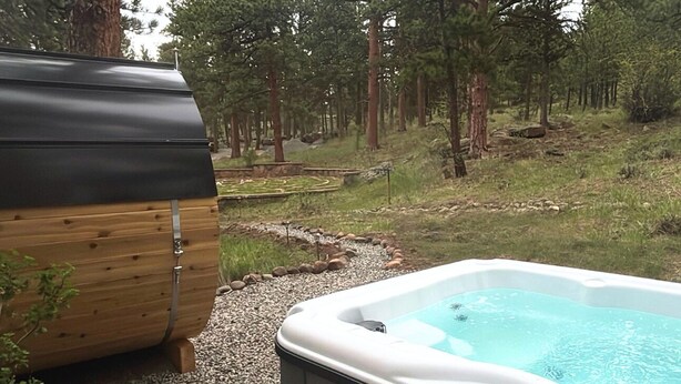 Lämminvesiallas, jonka ympärillä on metsäinen alue ja lähellä puinen rakennelma.