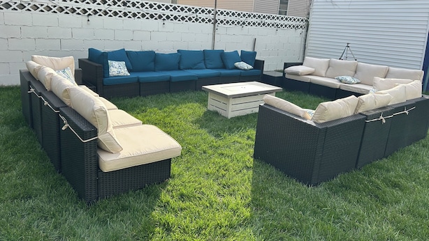Un patio al aire libre con un sofá modular, una mesa de centro y una mesita.