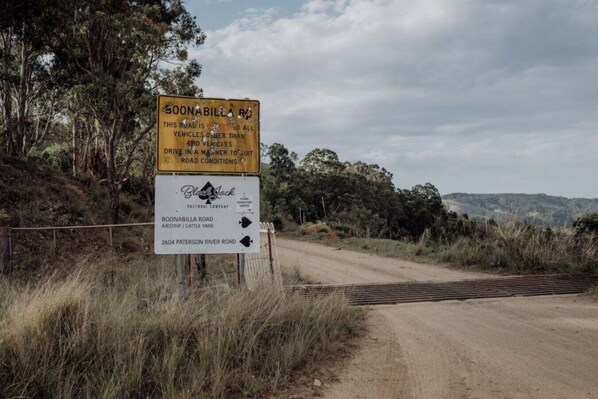 Et vejskilt i landlige omgivelser med angivelser af Boonabilla Road og Paterson River Road.