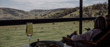 Una pareja sentada en una mesa con vistas al paisaje rural.