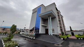 A modern building with a prominent blue vertical element, a balcony, and a staircase leading to the entrance. - Dominion City Guest House (Ibadan)