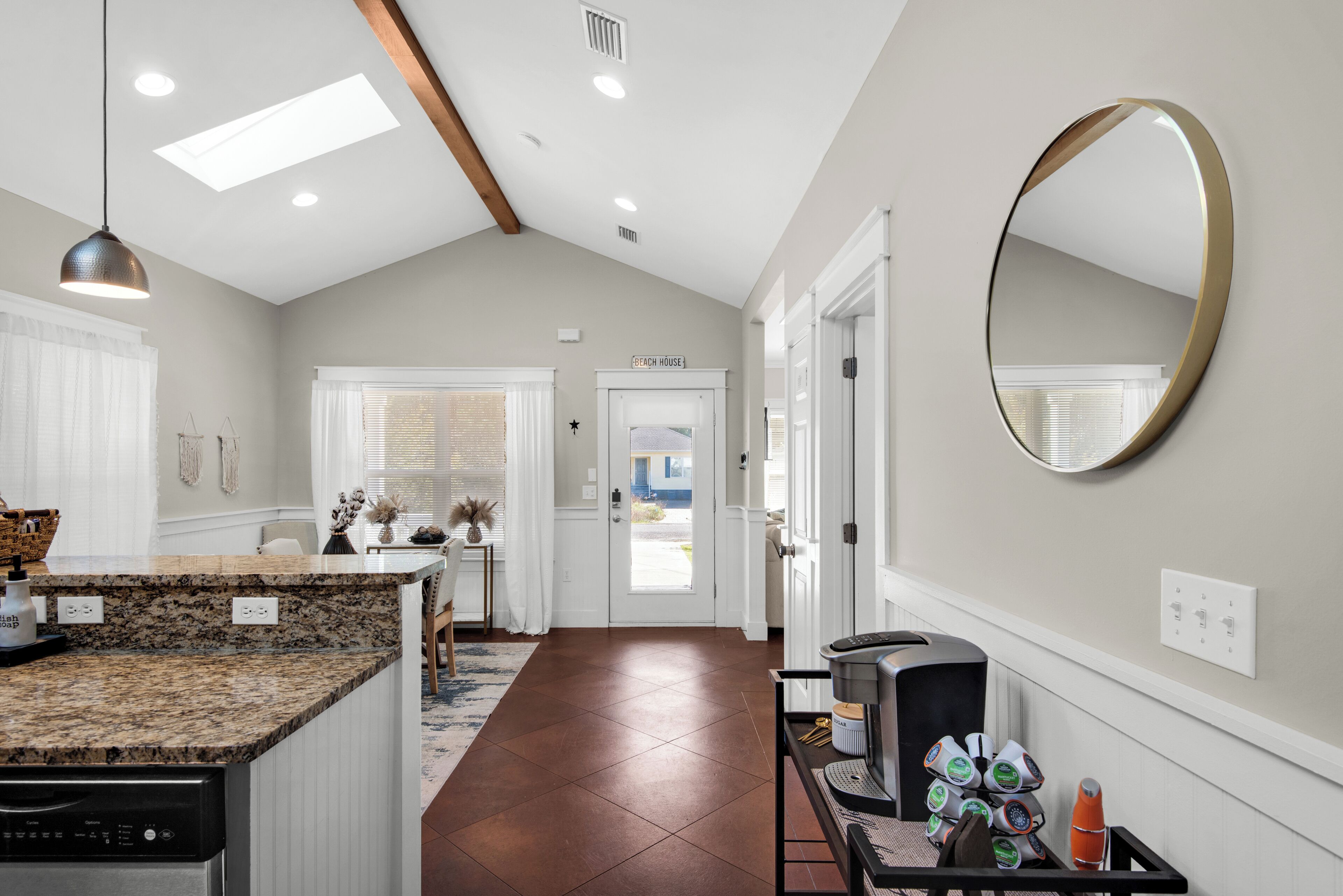 A kitchen with granite countertops, a dishwasher, and a coffee machine.