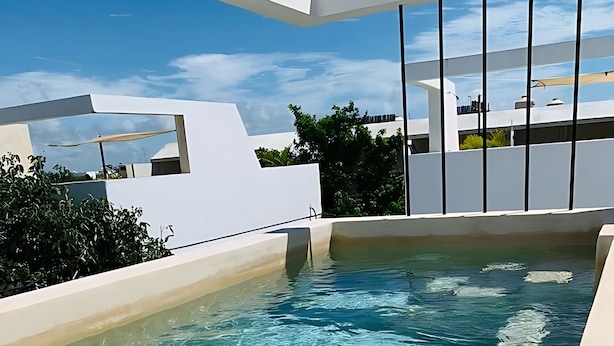 A modern rooftop pool with clear water, surrounded by white architecture and greenery. - Tulum Penthouse Retreat With Private Pool and Stunning Sunset Views (Tulum)