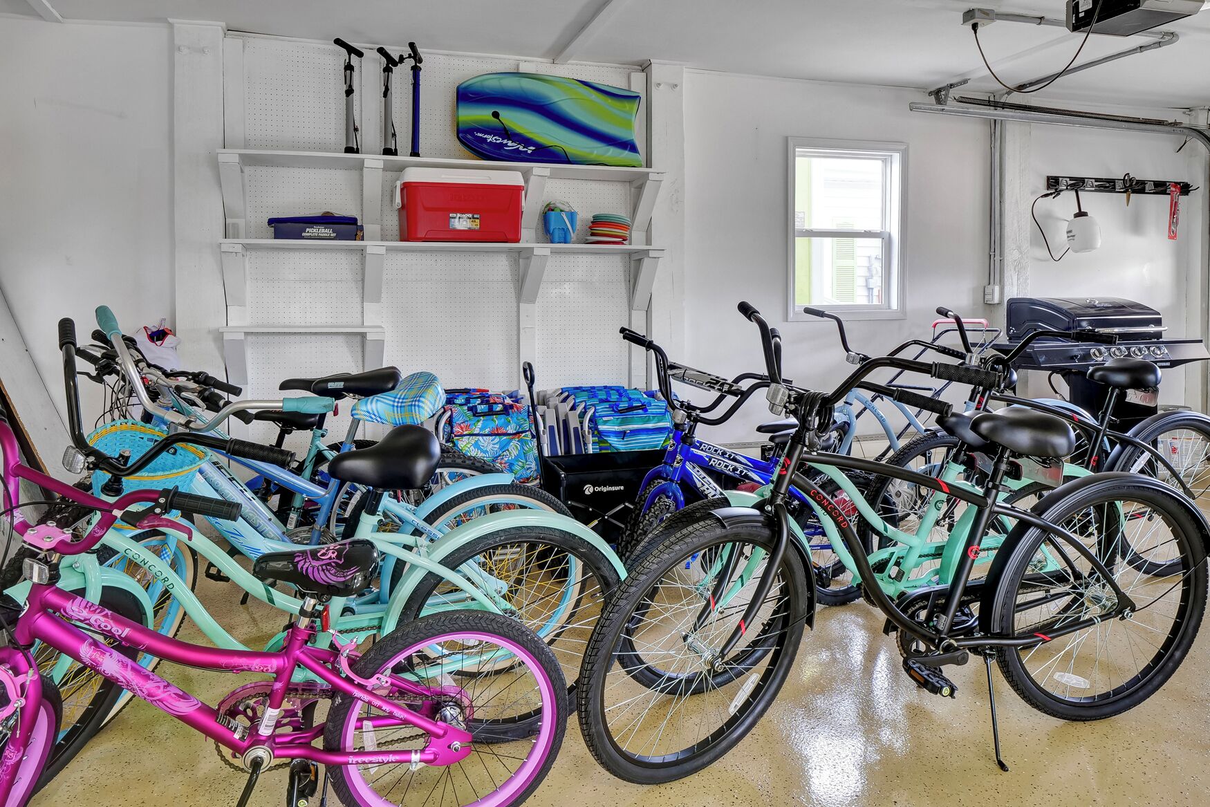 A room with bicycles, shelves with sports equipment, and a window.