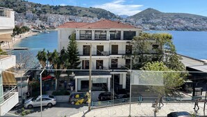 A multi-story building with balconies overlooking a coastal area. - Italian design apartment for a refined explorer of new destinations. (Saranda)