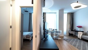A modern hotel room with a bed, a dining area, and a seating area with a sofa and a table. - Luxury apartment 300 meters from Milan Cathedral and Piazza San Babila (Milano)