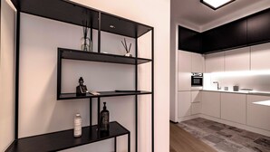 A modern kitchen with black shelving units, a built-in oven, and a minimalist design. - Luxury apartment 300 meters from Milan Cathedral and Piazza San Babila (Milano)