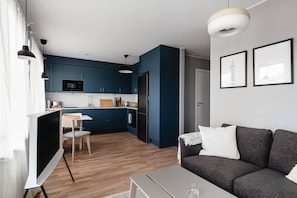 A modern apartment with a kitchen, dining area, and living room.
