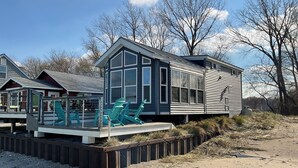 A modern house with a large deck and outdoor seating.