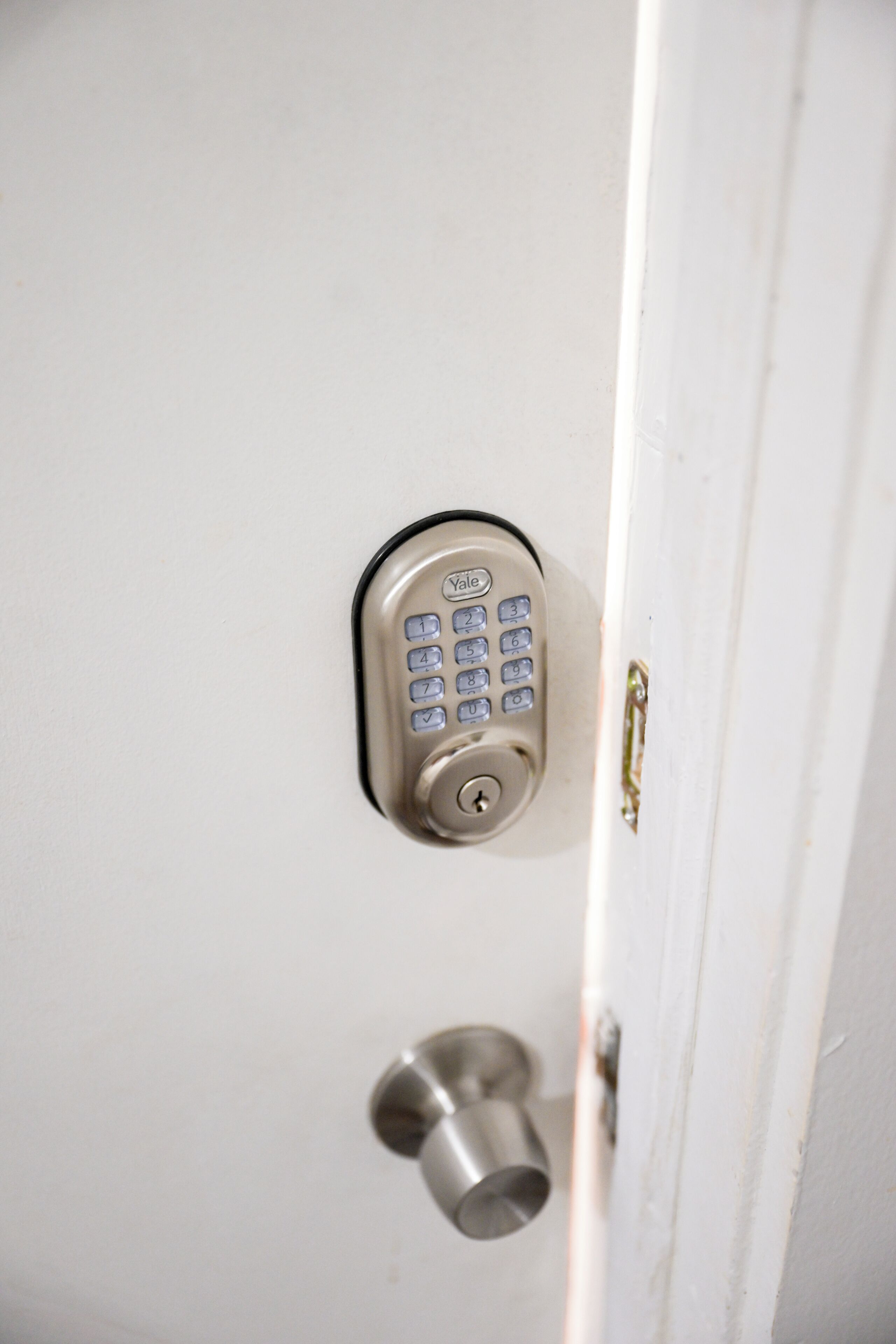 A Yale keypad lock on a white door.