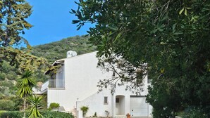 Un edificio blanco con un camino de piedra que lleva a un garaje.
