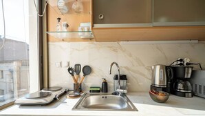 A modern kitchen with a marble countertop, stainless steel sink, and a coffee maker. - Athenais 3A 2 bedroom 4 persons apartment by MPS (Athina)