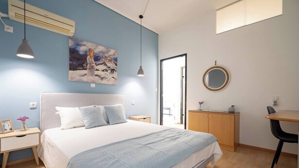 A bedroom with a bed, bedside tables, a desk, a mirror, and a painting on the wall. - Athenais 3A 2 bedroom 4 persons apartment by MPS (Athina)