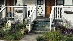 A two-story house with a porch, a front door, and a staircase leading to the entrance. - 1 block to Trolley, Short walk to Historic Cemeteries, Clean, Coffee Bar (New Orleans)