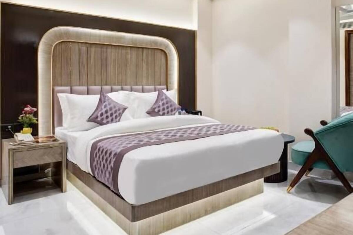 A modern bedroom with a large bed, a ceiling fan, and a bedside table with a lamp.