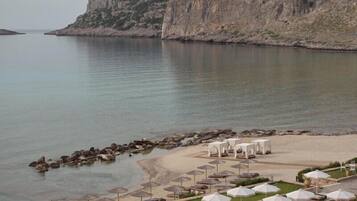 En la playa, sillas reclinables de playa, sombrillas, toallas de playa