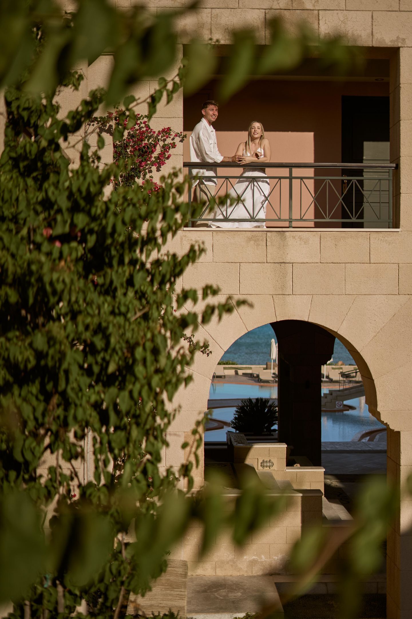 Ein Balkon mit Blick auf einen Pool und ein Gebäude.