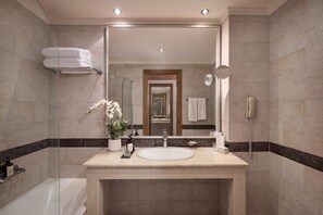 Un baño moderno con un espejo grande, un lavabo y una ducha.