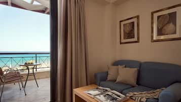 En stue med sofa, sofabord og en balkon med havudsigt.
