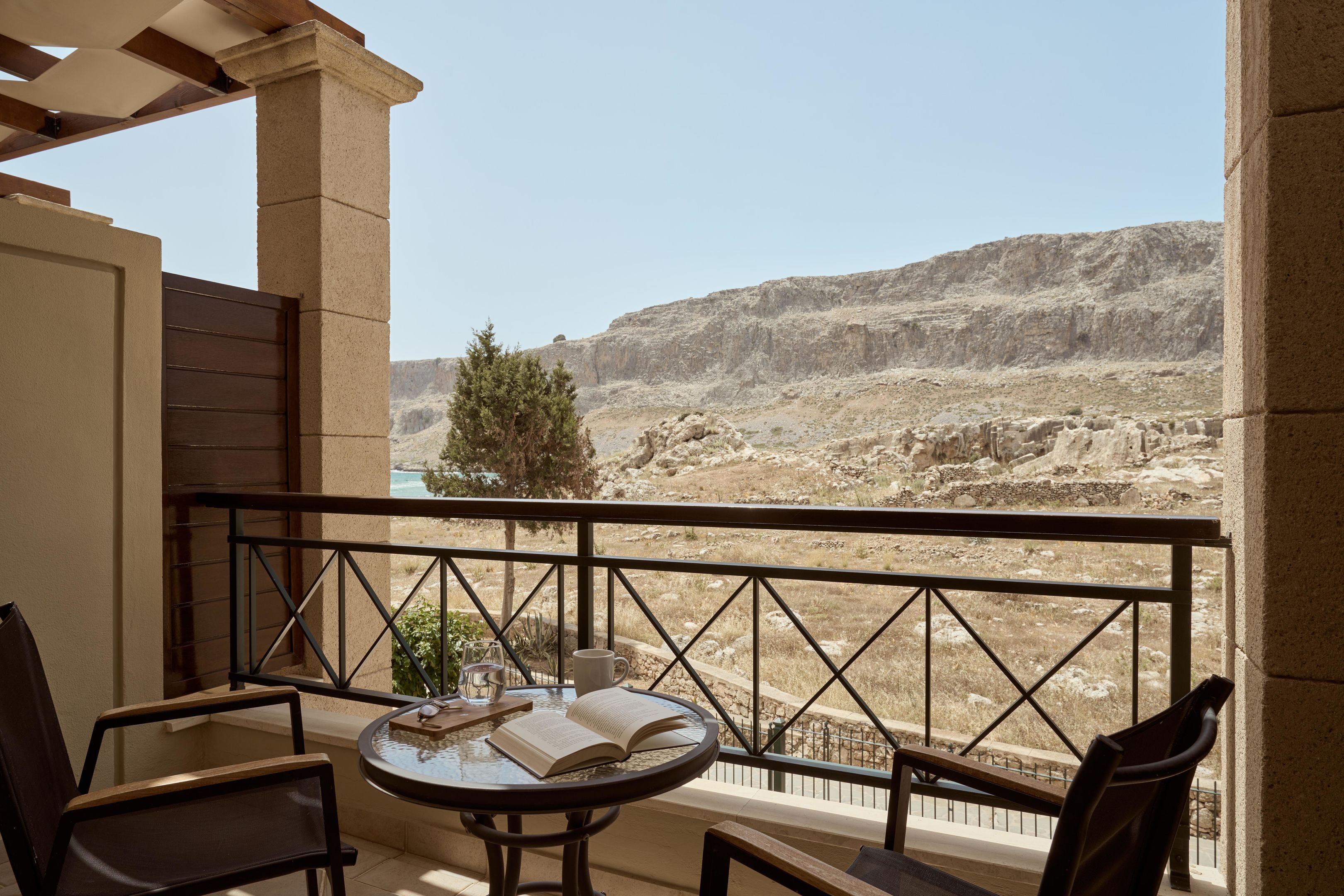 A balcony with a table, chairs, and an open book.