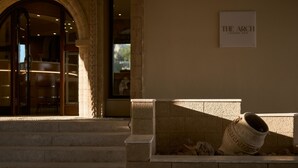 Una entrada de piedra con un letrero que dice 'THE ARCH LOUNGE BAR'.