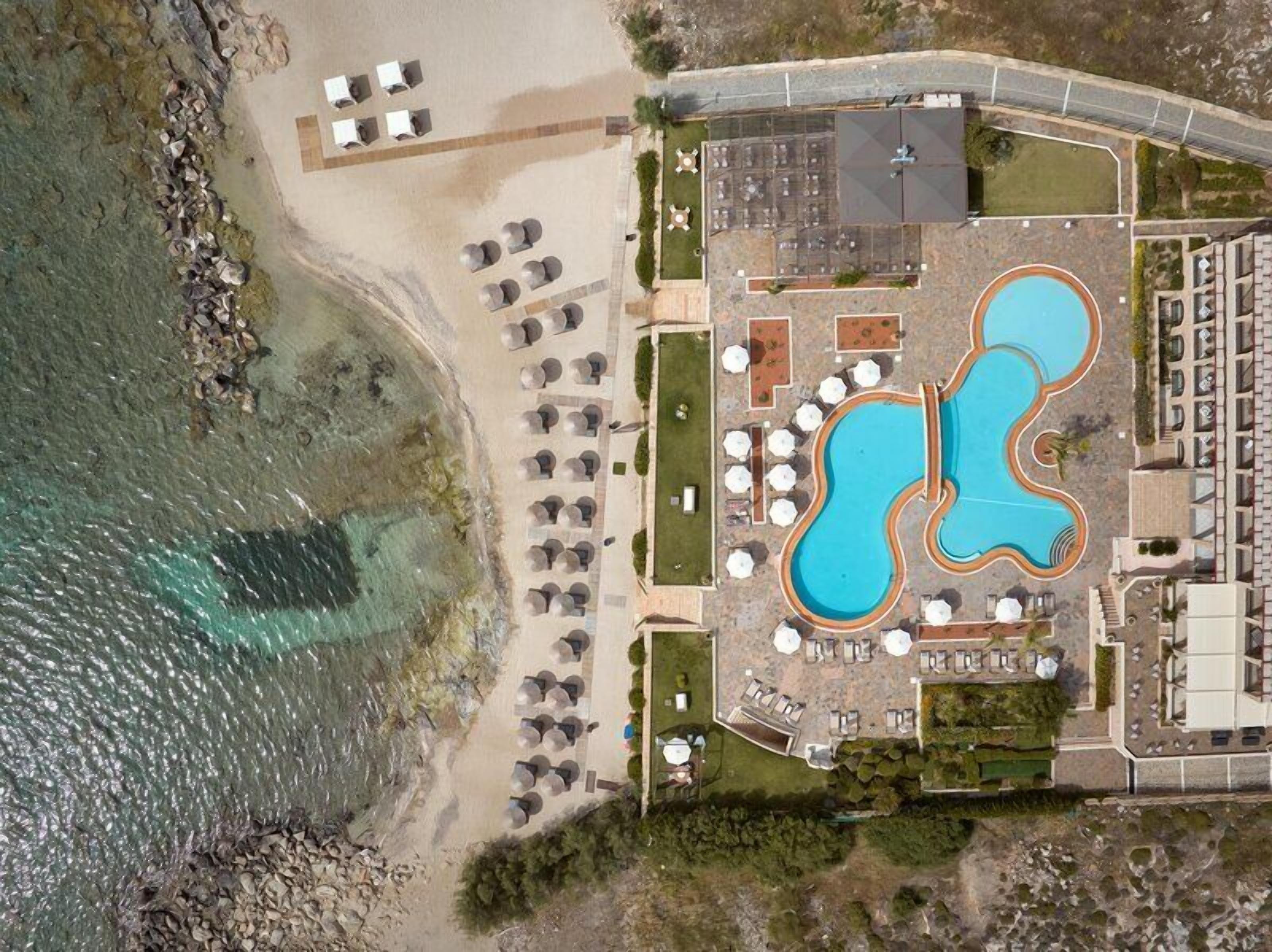 Una piscina al aire libre de temporada, sombrillas