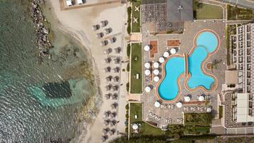 Una piscina al aire libre de temporada, sombrillas