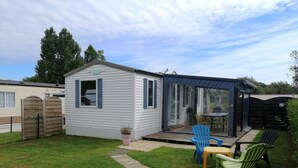 A small, single-story mobile home with a covered patio area.