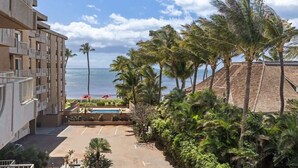A hotel with a pool, palm trees, and a view of the ocean. - Partial oceanview 1 bedroom condo, AC, 6 mile sandy beach (Kihei)