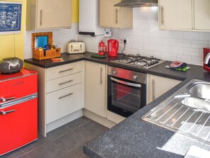 A kitchen with a red appliance, a gas stove, a toaster, and a sink. - 2 bedroom accommodation in March, near Wisbech (March, near Wisbech)