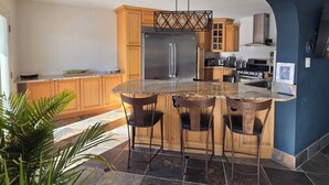 Une cuisine moderne dotée d’un îlot central, de meubles en bois et d’une cuisinière intégrée.