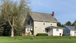 A two-story house with a sloped roof, a chimney, and a front porch. - Family-friendly farmhouse property, rural setting, 10 minutes from Tiffin, OH. (Republic)