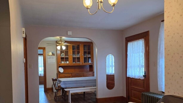 A living room with a brown sofa, a wooden cabinet, and a dining table with chairs. - Family-friendly farmhouse property, rural setting, 10 minutes from Tiffin, OH. (Republic)